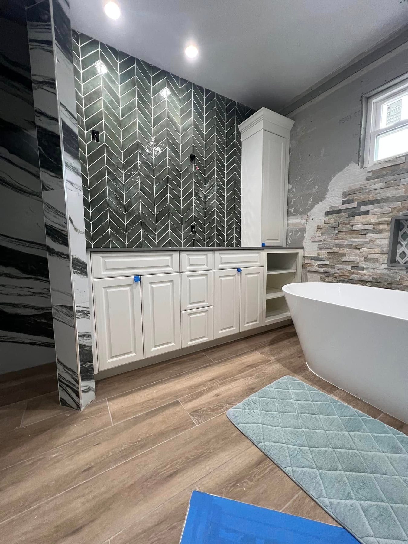 Custom bathroom cabinetry with a tiled arch and freestanding tub
