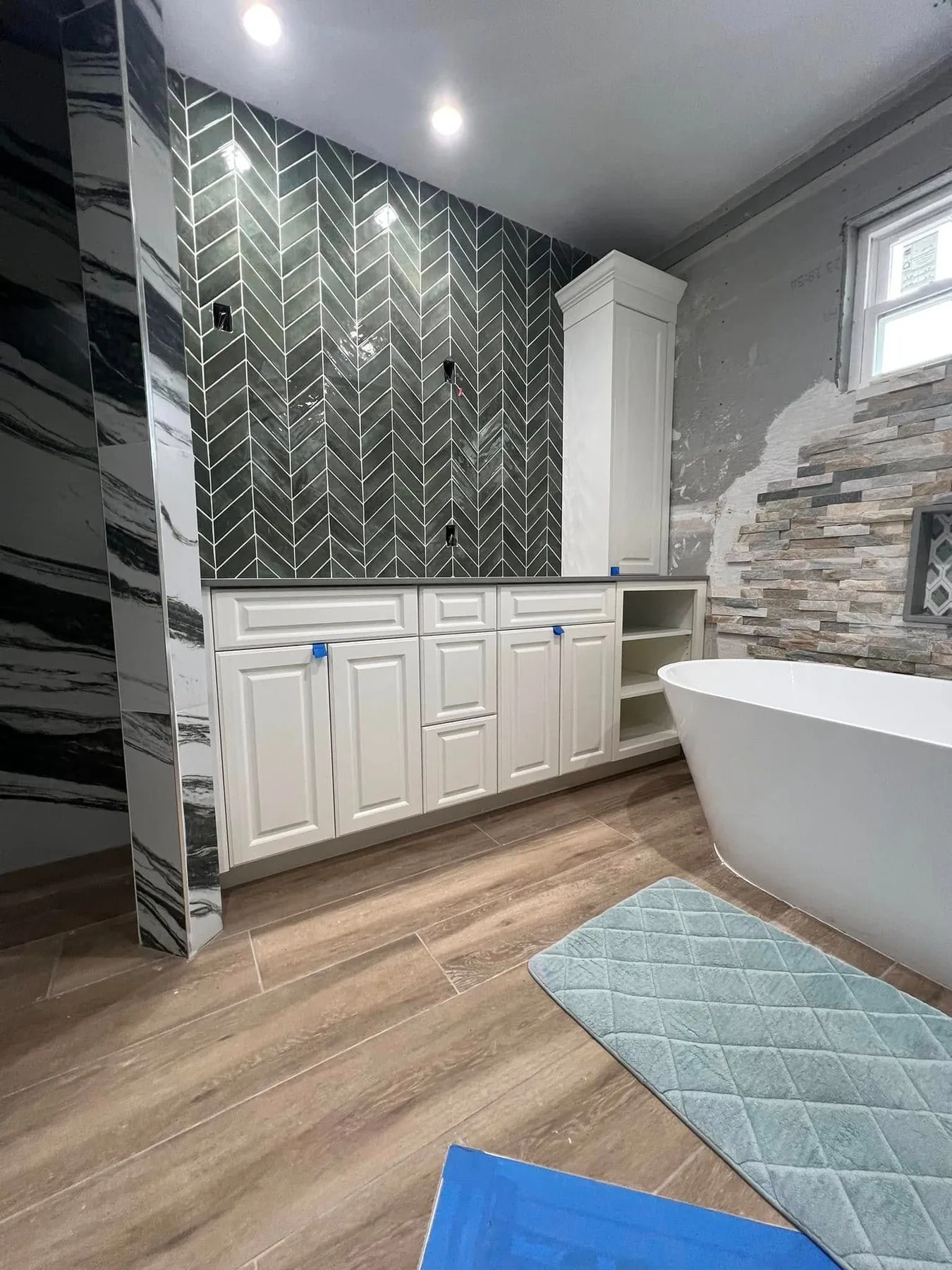 Custom bathroom cabinetry with a tiled arch and freestanding tub