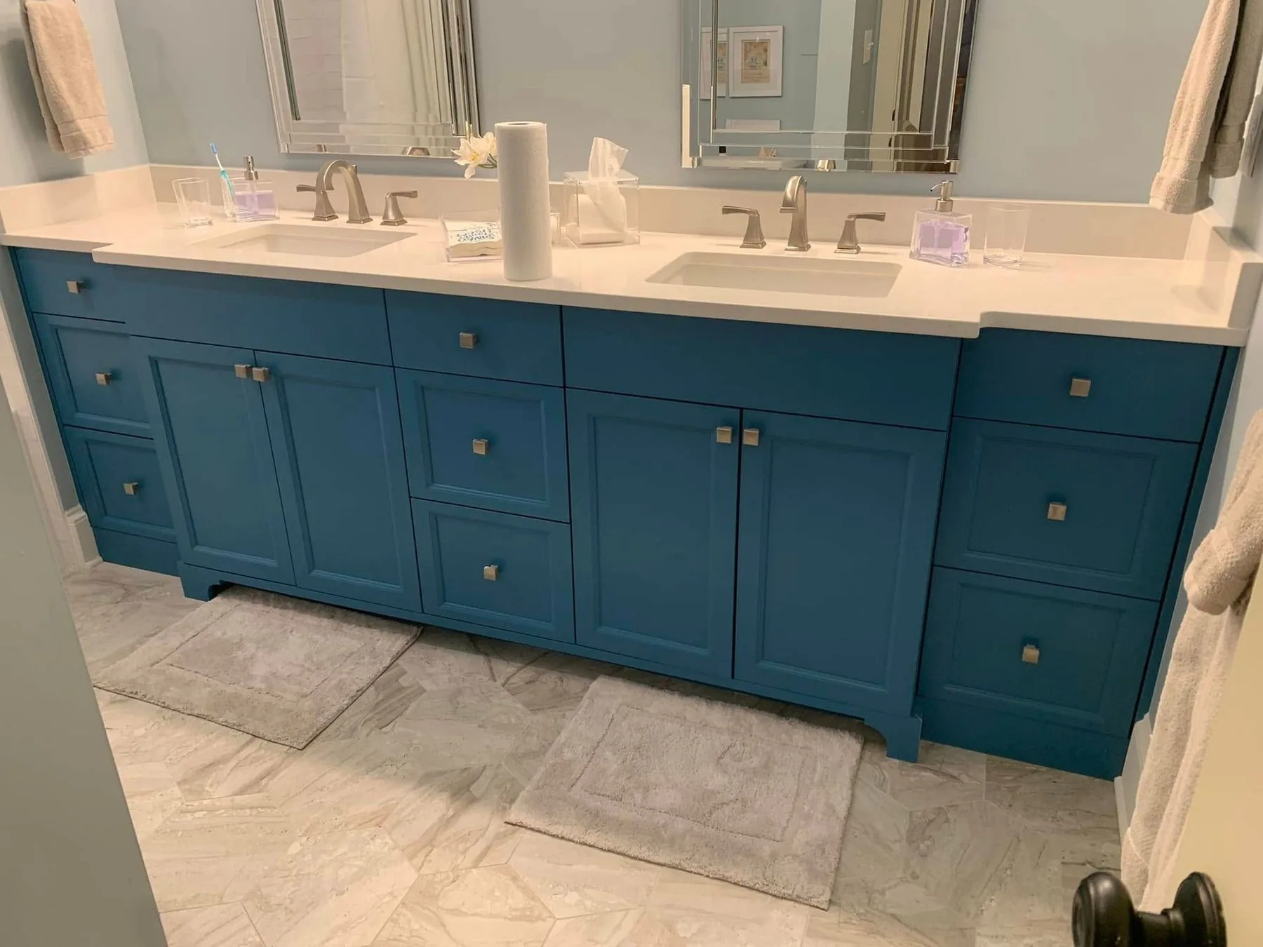 Custom navy double vanity with stone countertop in a Charlotte bathroom