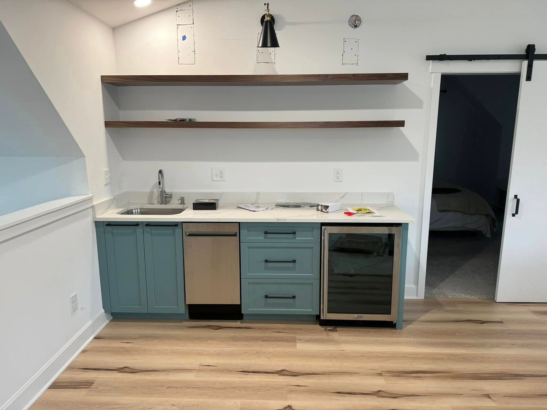 Custom mudroom and bar cabinetry with a sliding barn door and open shelving