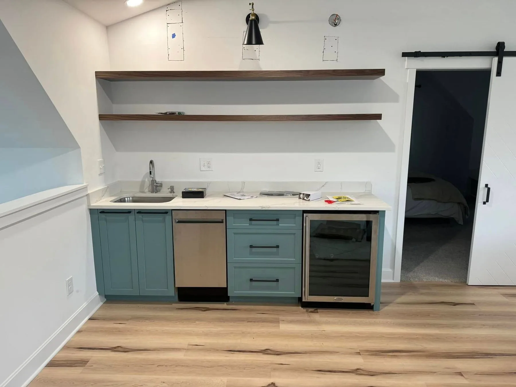 Custom mudroom and bar cabinetry with a sliding barn door and open shelving
