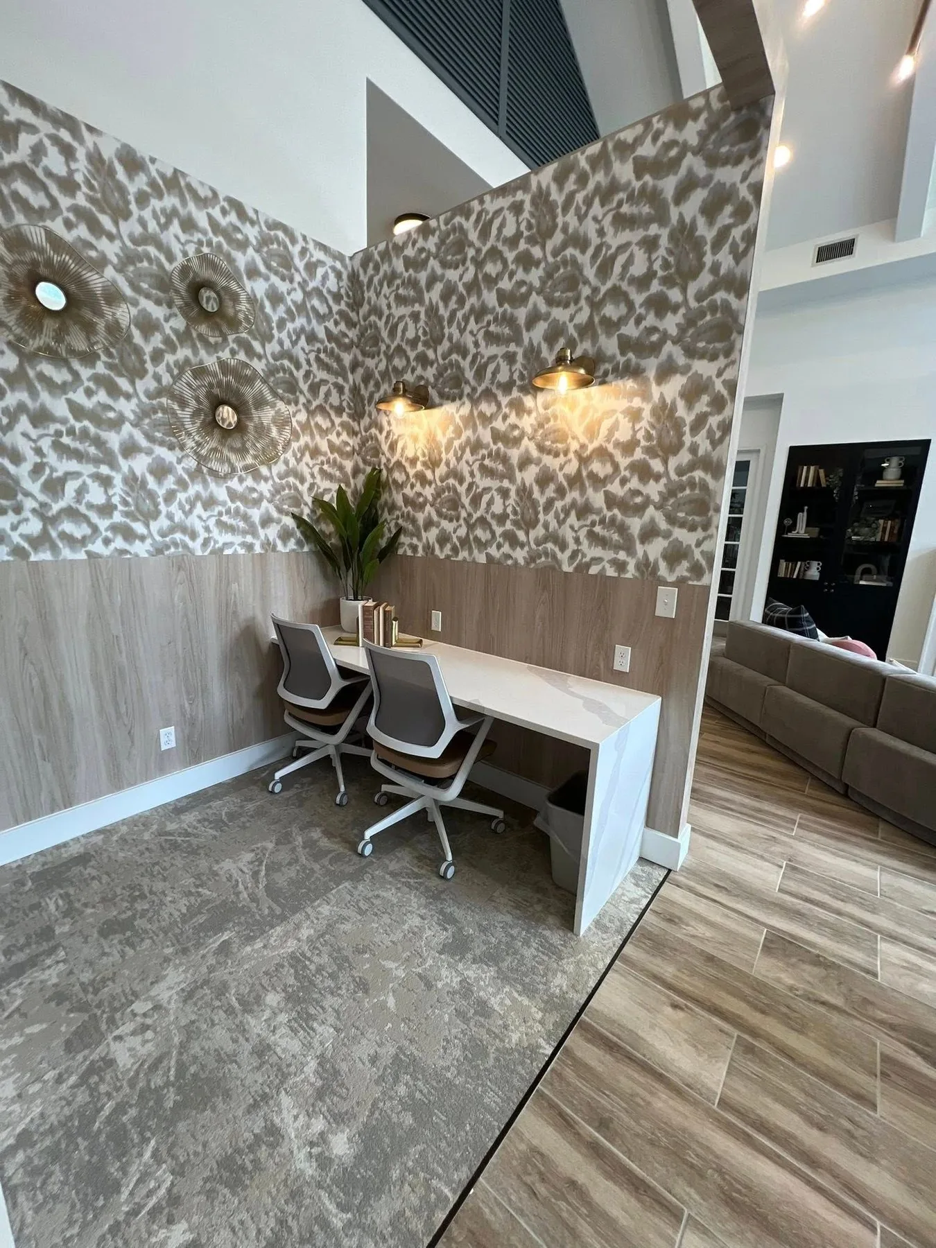 Custom home office cabinetry with a built in desk and dark painted base cabinets